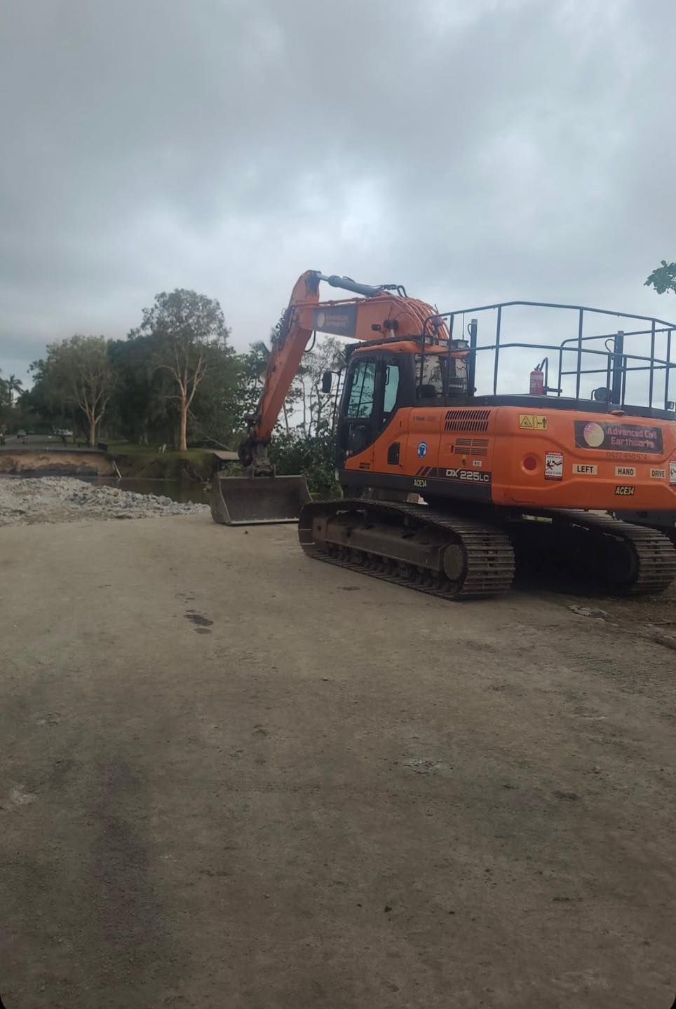 A Large Orange Excavator is Parked in a Dirt Lot — Advanced Civil Earthworks In Koah, QLD