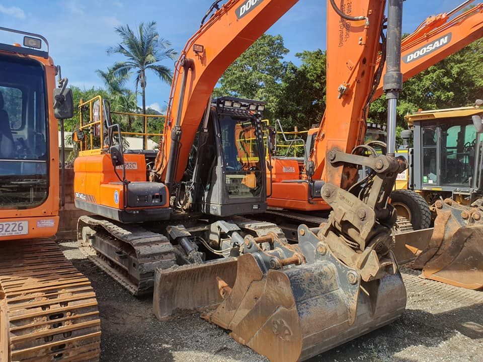 A Large Orange Excavator is Parked Next to a Smaller Orange Excavator — Advanced Civil Earthworks In Koah, QLD