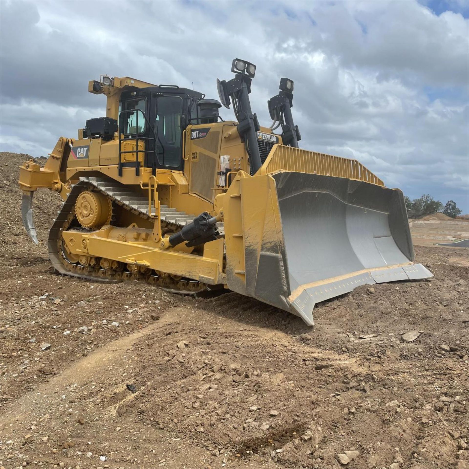 A Yellow Bulldozer is Parked in a Dirt Field — Advanced Civil Earthworks In Innisfail, QLD