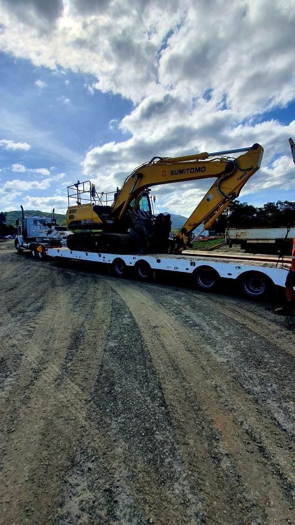 A Large Yellow Excavator is Sitting on Top of a Flatbed Trailer — Advanced Civil Earthworks In Port Douglas, QLD
