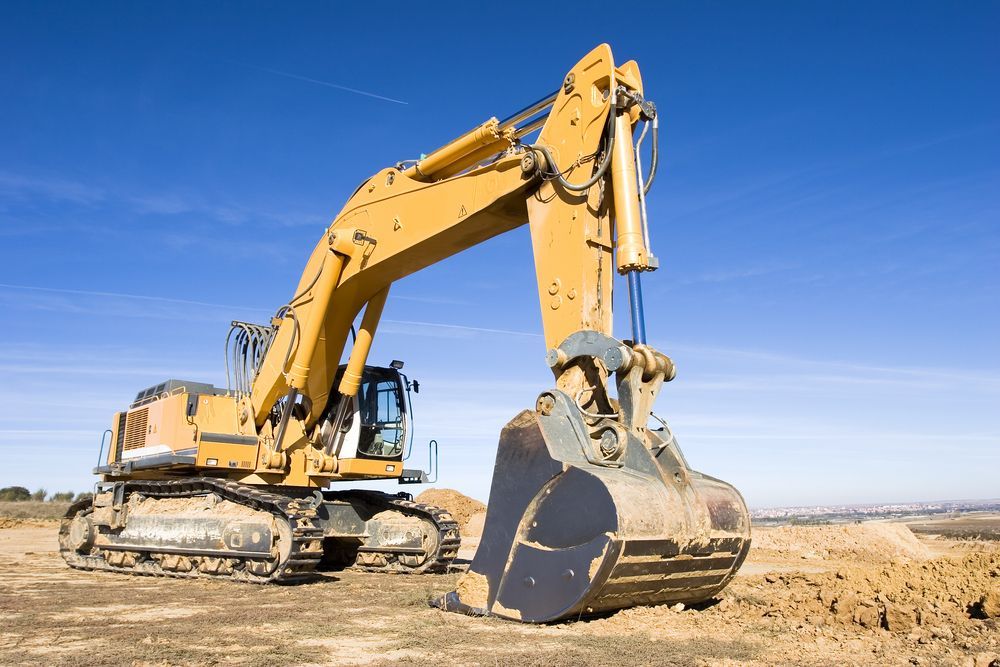 A Large Yellow Excavator is Sitting on Top of a Dirt Field — Advanced Civil Earthworks In Koah, QLD