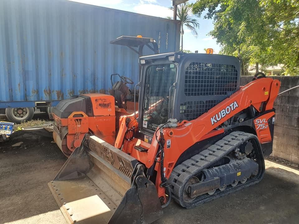 A Bulldozer is Parked Next to a Blue Container — Advanced Civil Earthworks In Port Douglas, QLD