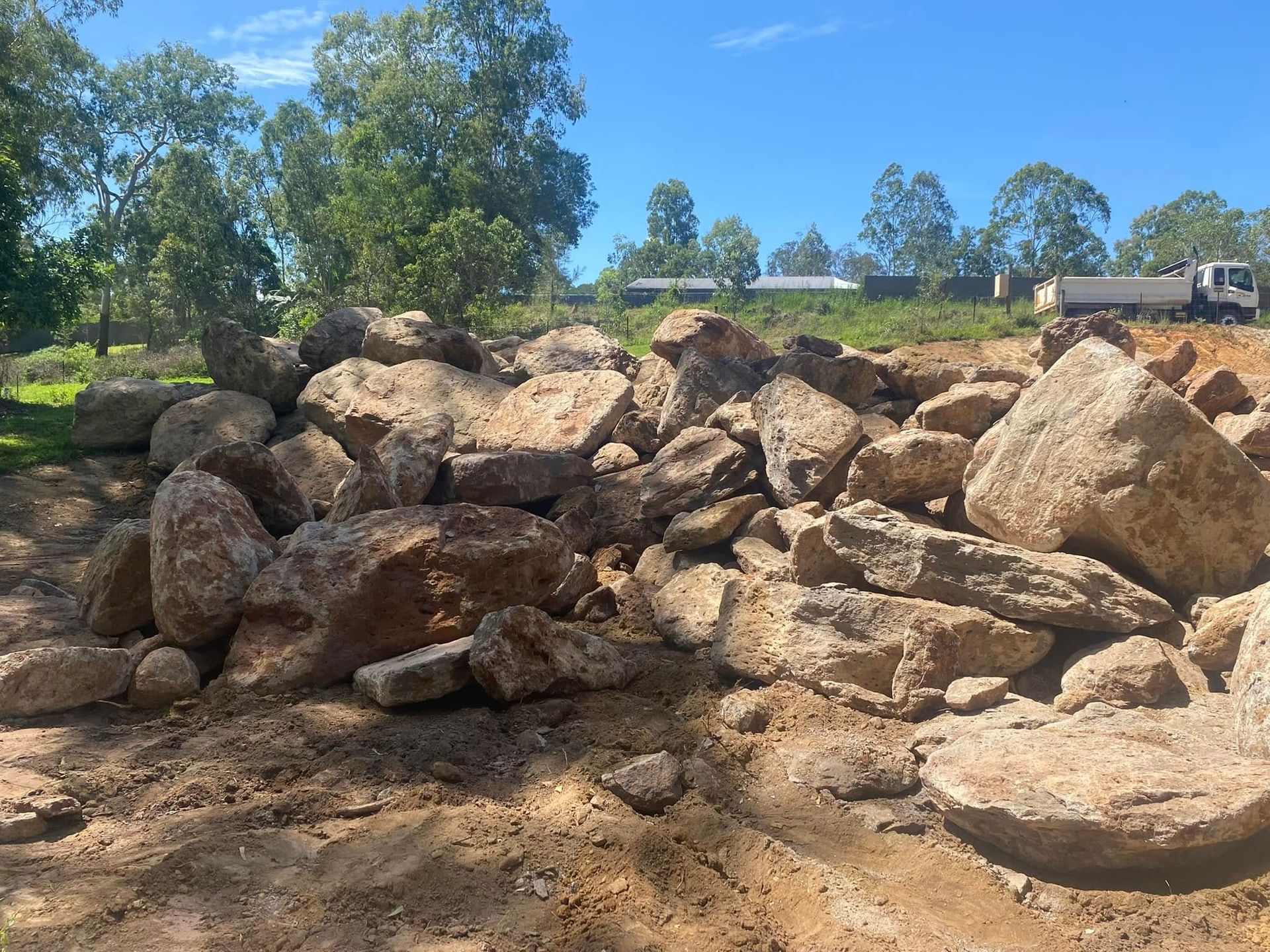 A pile of rocks is sitting on top of a dirt field — Advanced Civil Earthworks In Koah, QLD