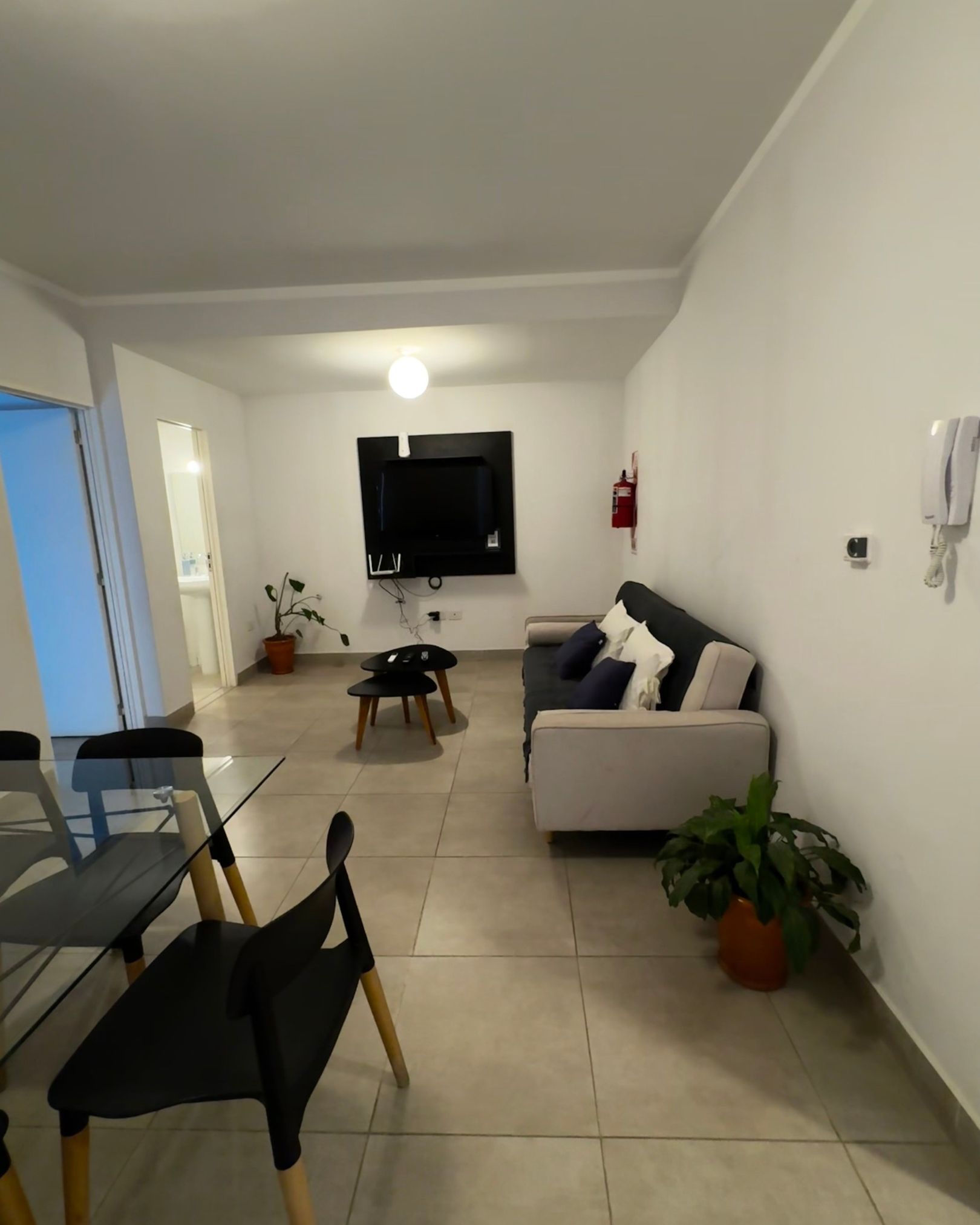 A living room with a couch and a tv on the wall