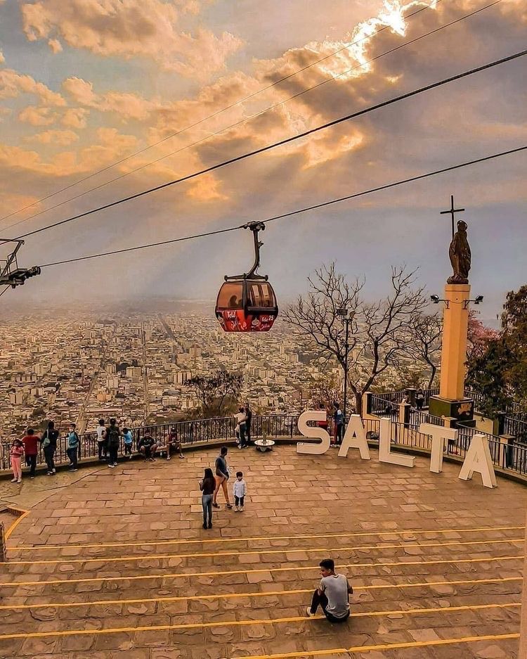 A cable car is going over a city.