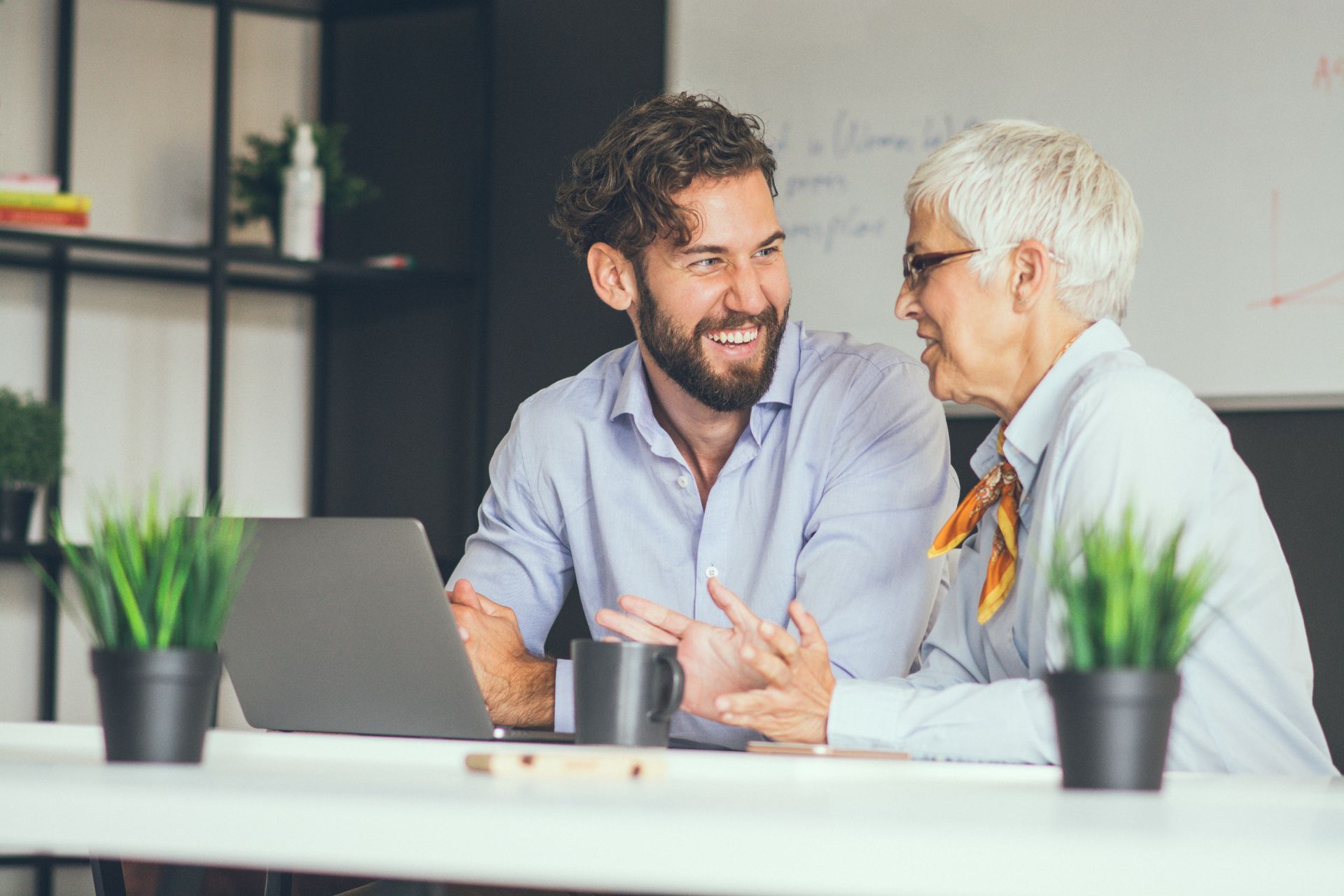 Un mentor senior et un professionnel plus jeune discutent dans un bureau de l'industrie pharmaceutique, symbolisant le rôle du mentorat pour le développement de compétences et la progression de carrière.