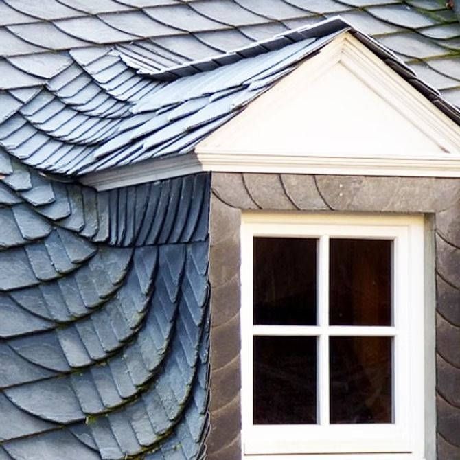 Slate-shingled dormer roof with a white-framed window and stone trim