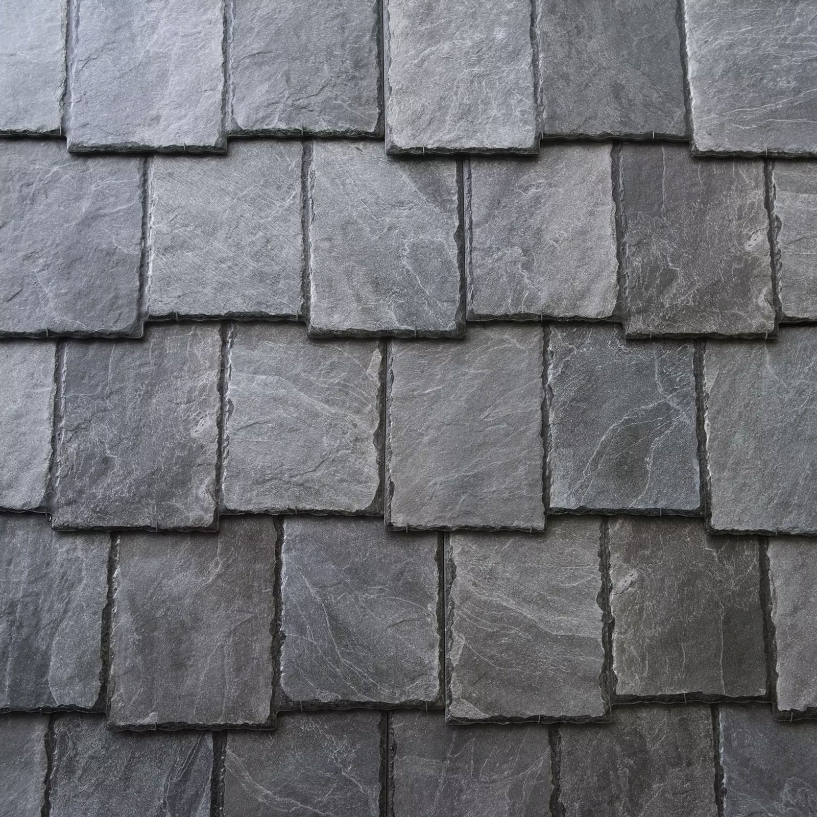 Close-up of gray slate roof shingles with overlapping rows