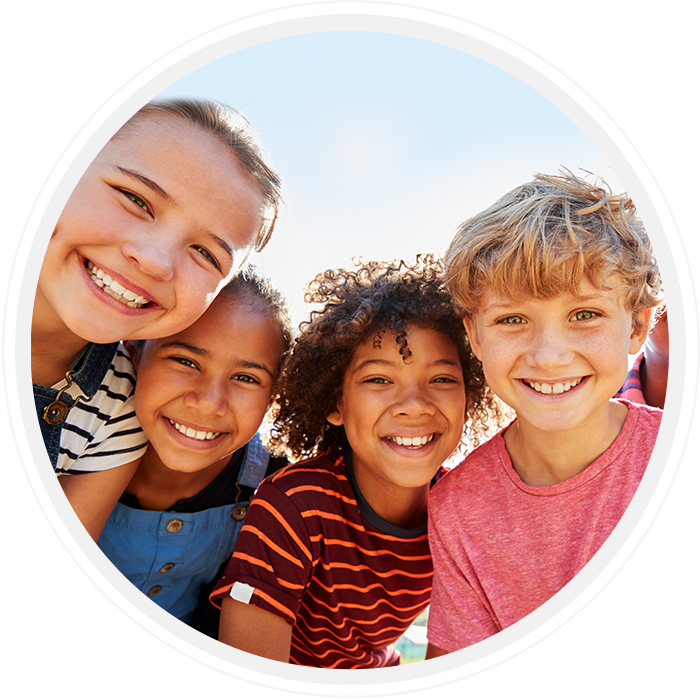 Four children smiling together outdoors