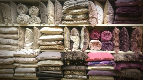 a shelf filled with lots of pillows - pillows for sale
