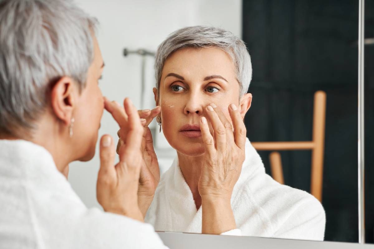 Woman with gray hair practicing skincare routine in bathroomnear Lexington, Kentucky (KY)