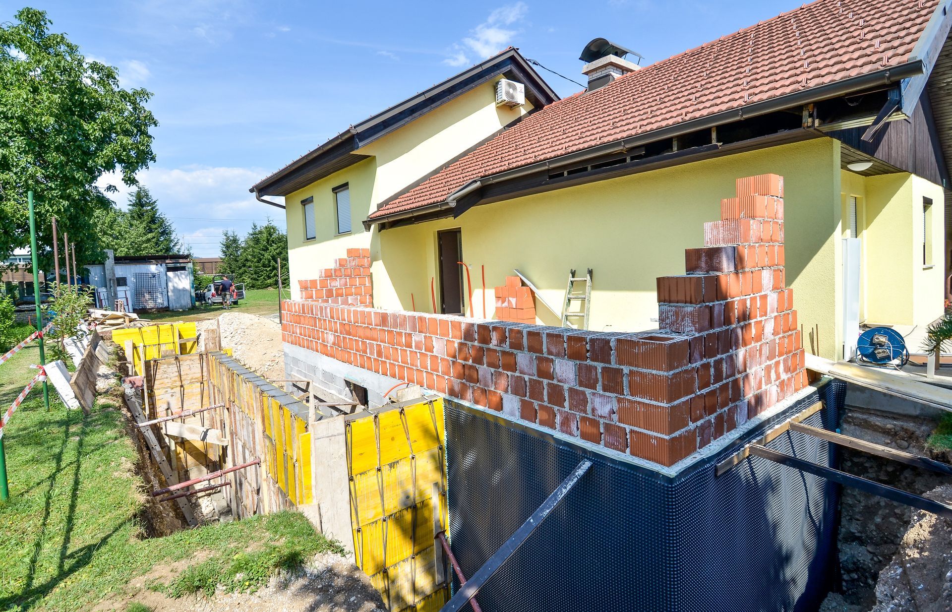 House Under Construction, Red Brick Being Added to Exterior — Peter Whelan Building Services in Wyoming, NSW