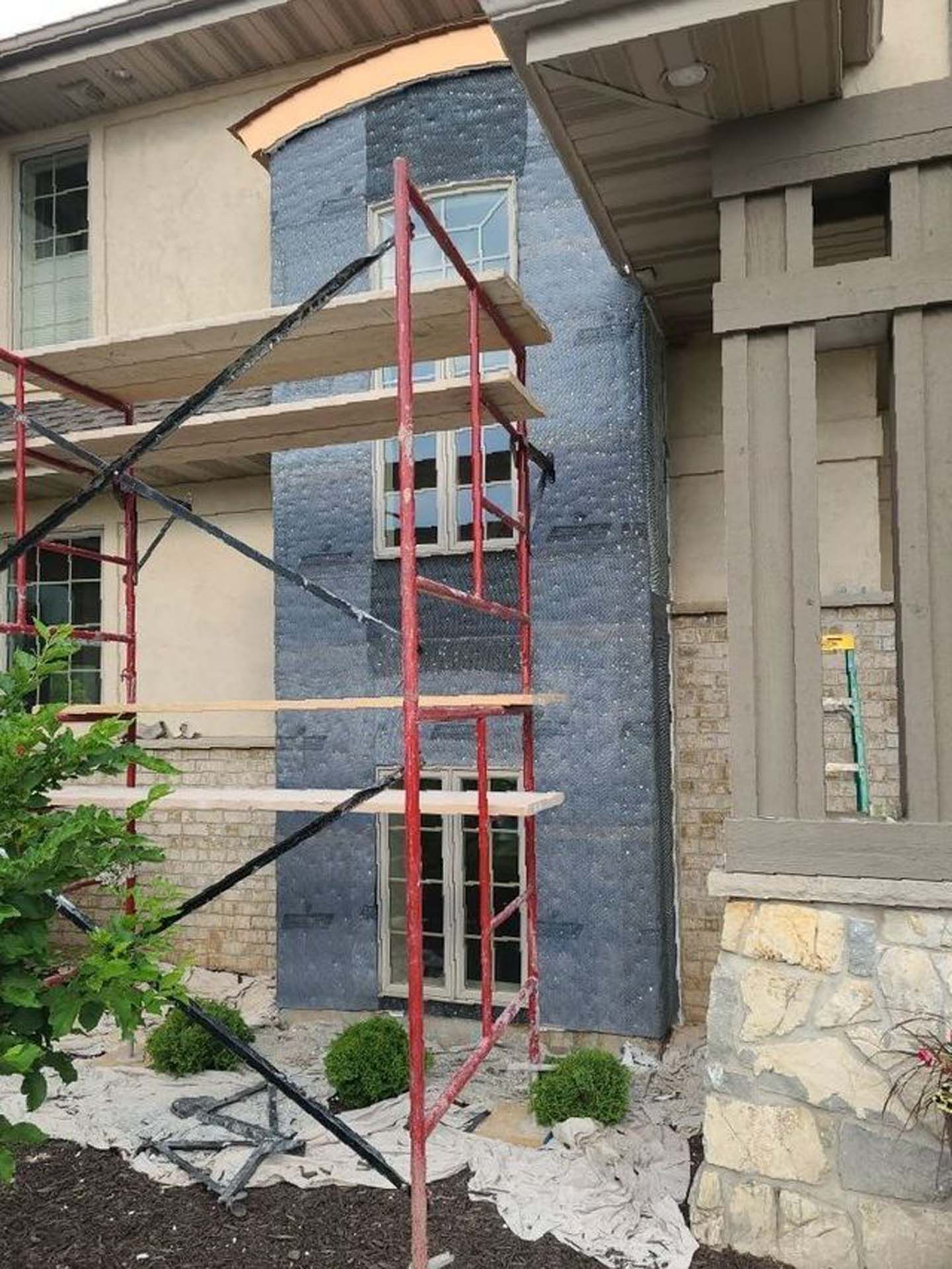 A red scaffolding is sitting in front of a house.