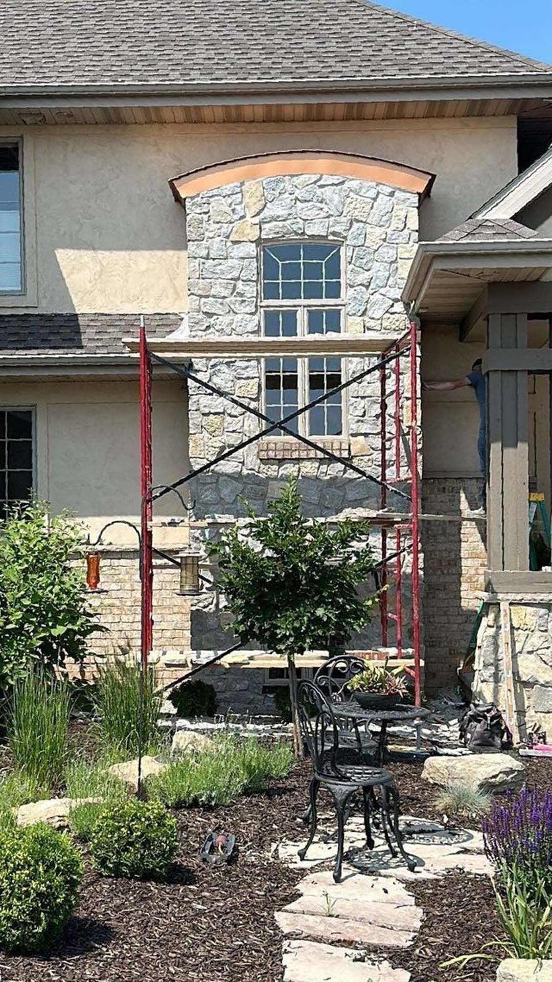 A house with a scaffolding in front of it is being remodeled.
