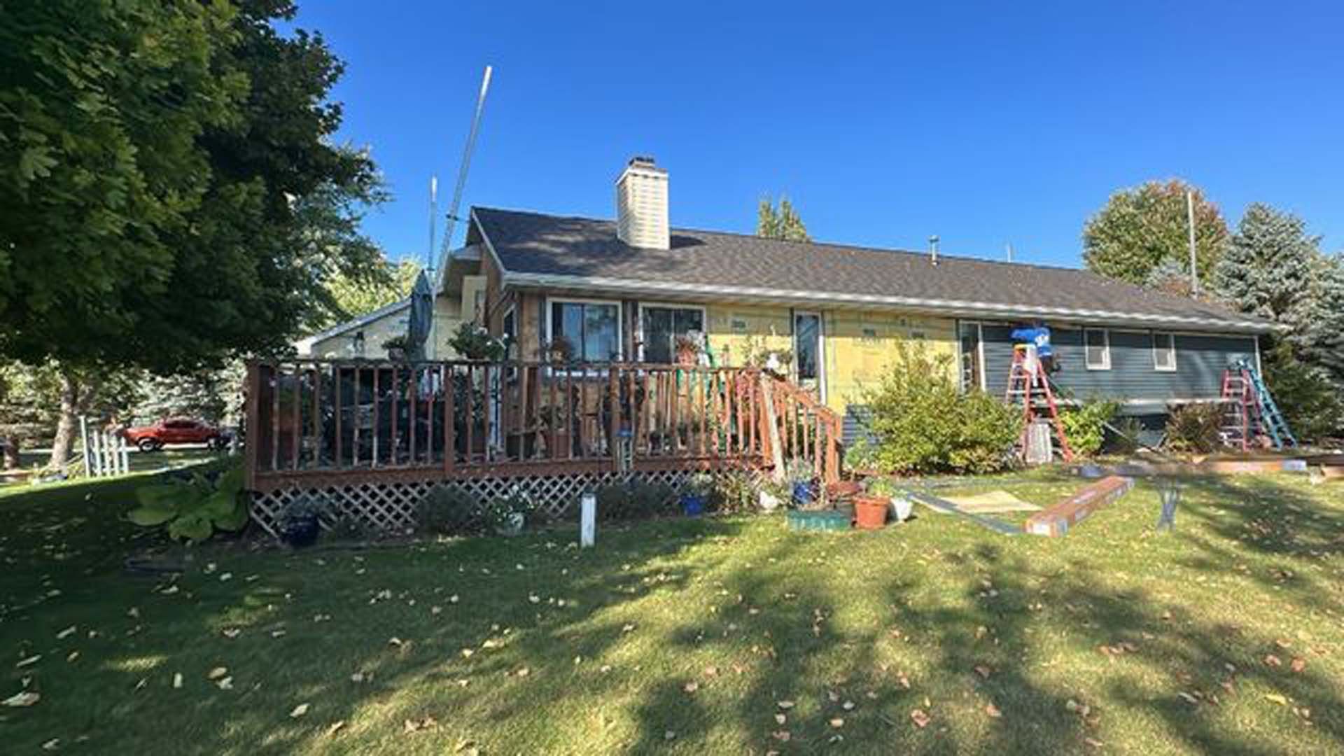 A large house with a large deck in the backyard.