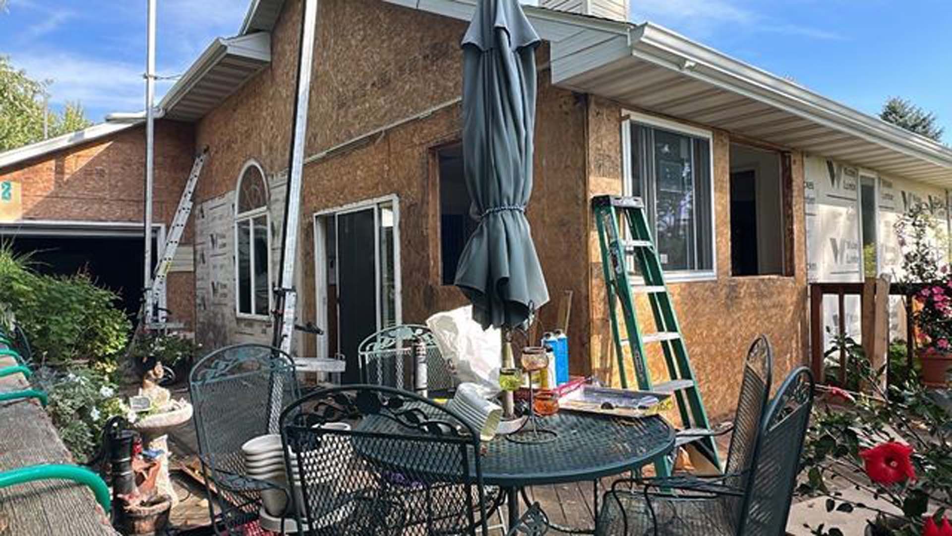 A house is being remodeled with a table and chairs in front of it.