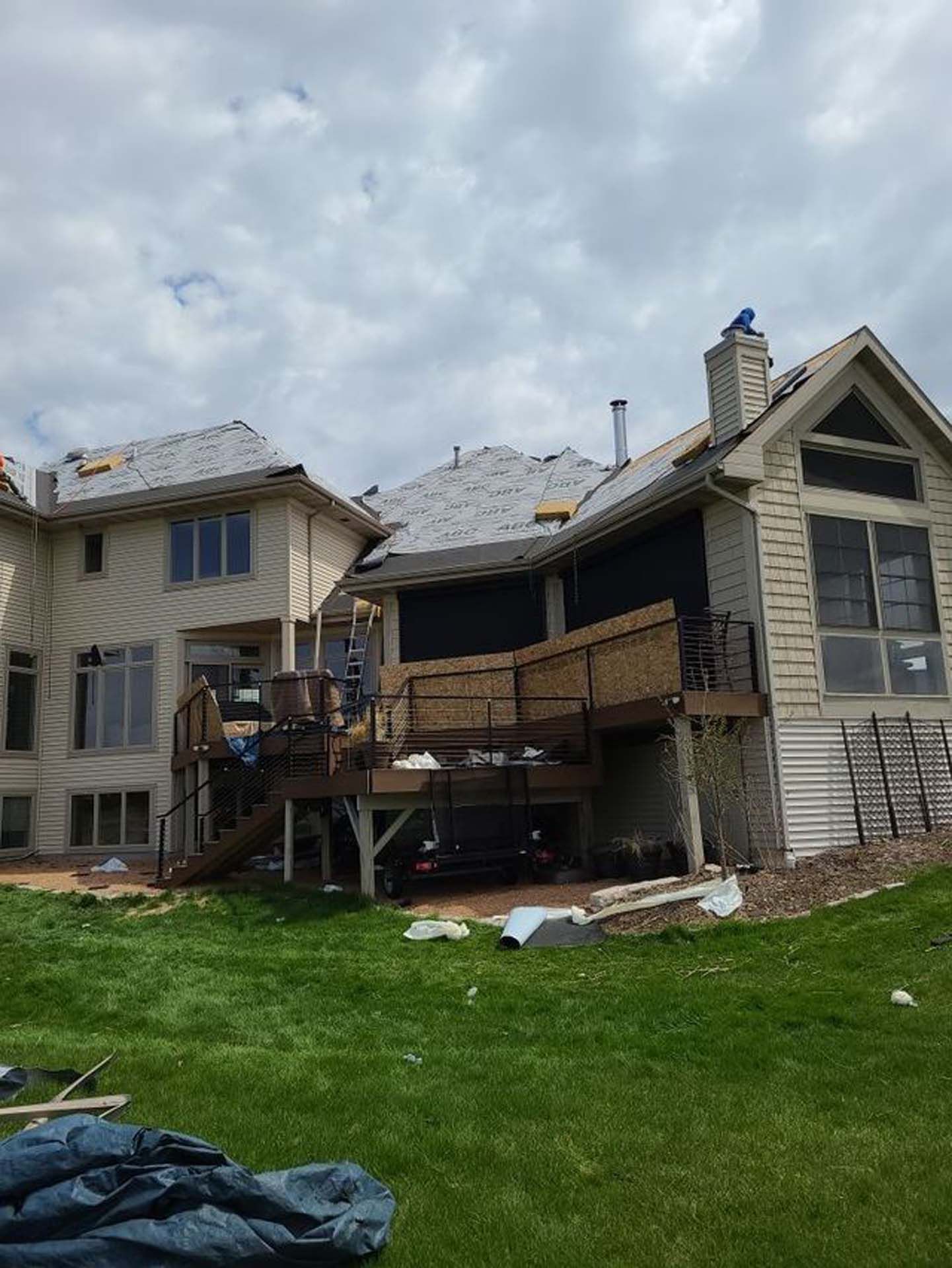 A large house with a deck and stairs is being built.