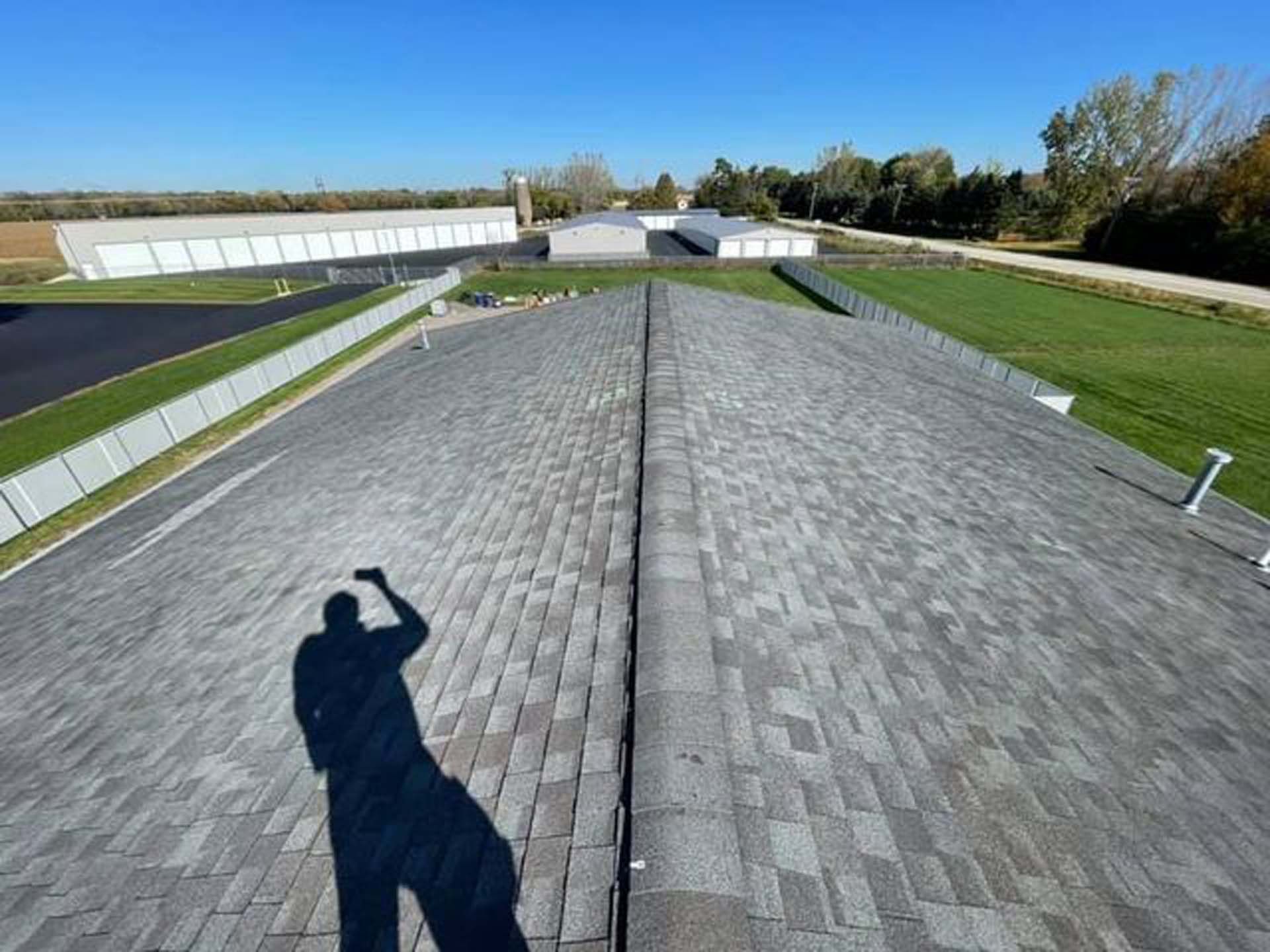 A shadow of a man is cast on the roof of a building.