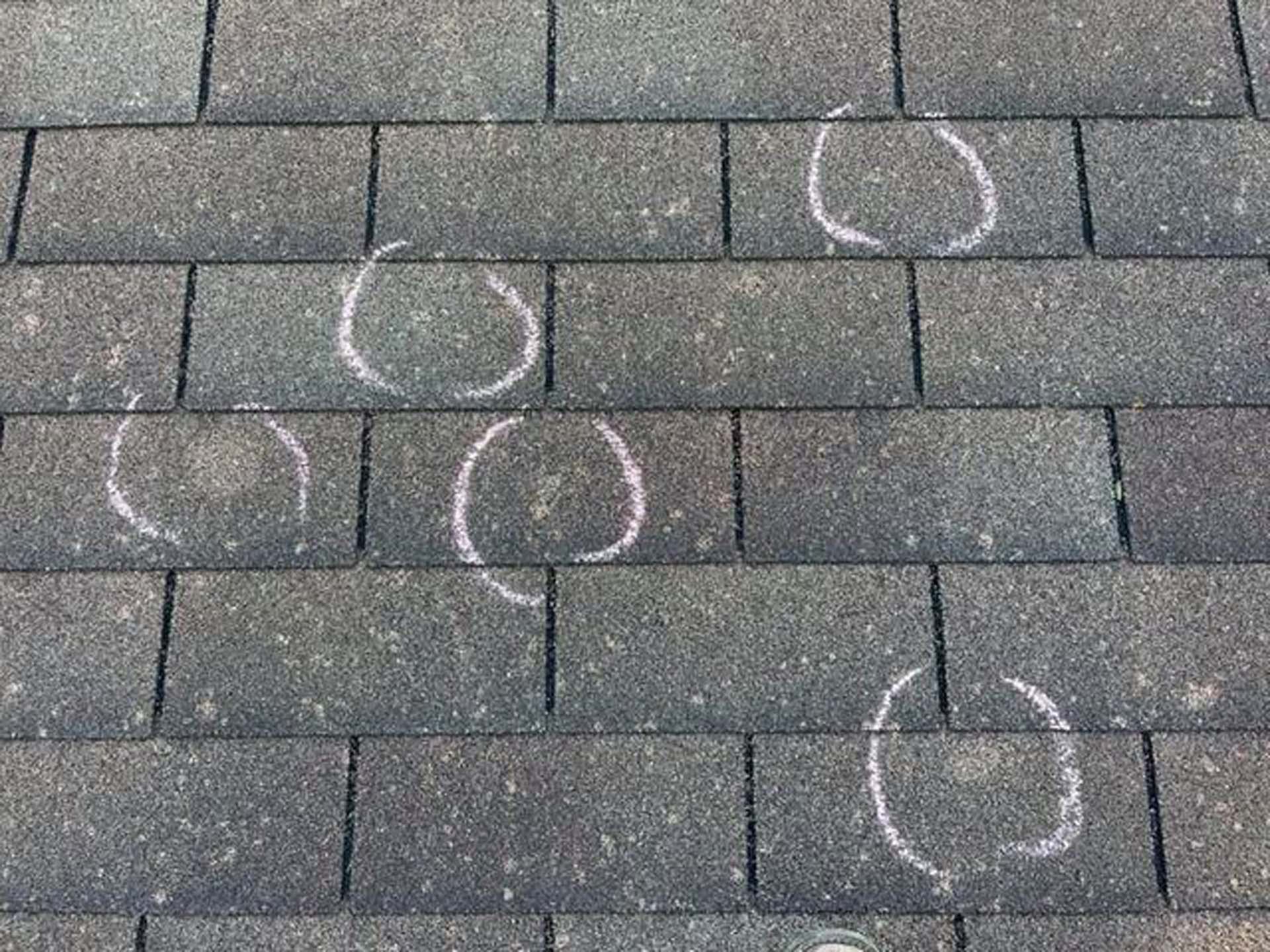 A close up of a roof with chalk circles drawn on it.