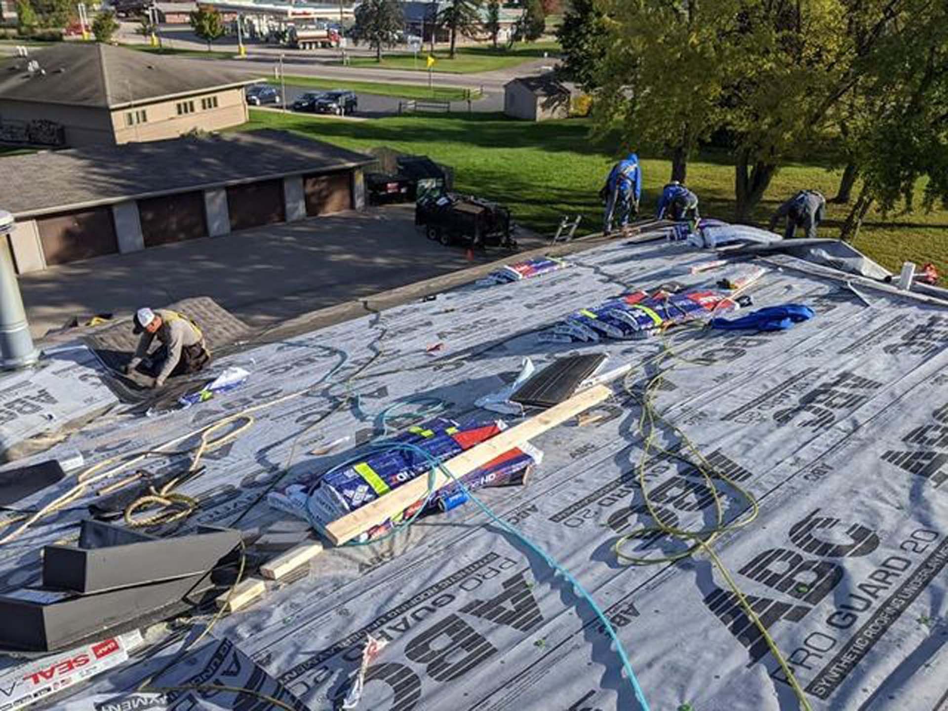 A group of people are working on a roof of a house.