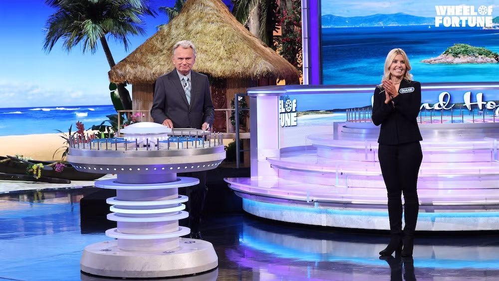 Diane Birnholz and Pat Sajak standing on stage at Wheel of Fortune