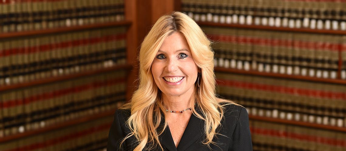 Diane Birnholz, Former Federal Prosecutor stands in a legal library