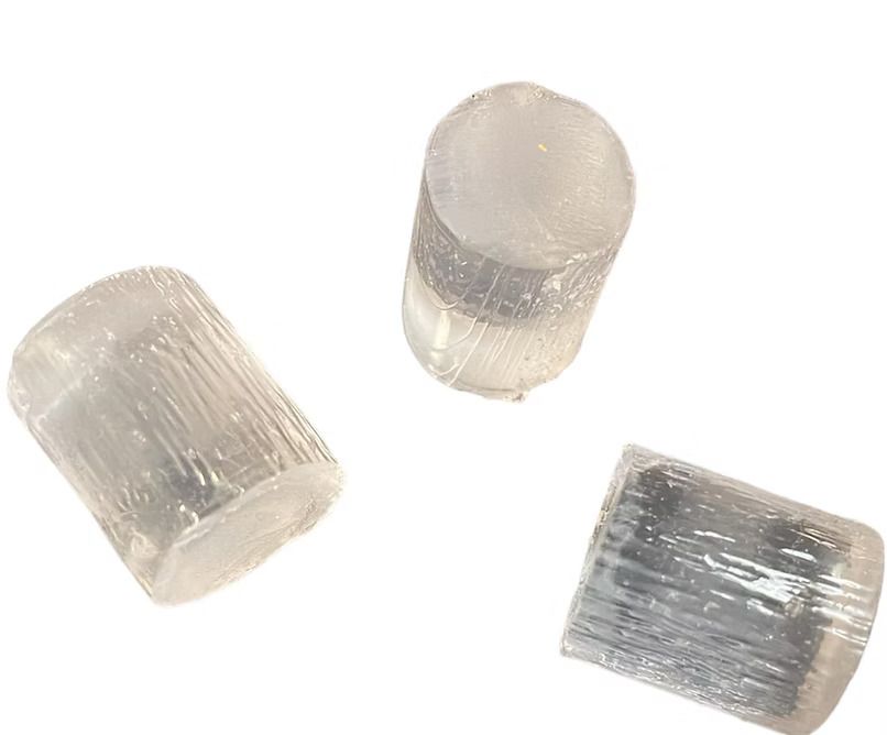 Three clear crystals are sitting on top of each other on a white surface.