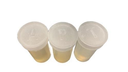 Three plastic containers with white lids filled with liquid on a white background.