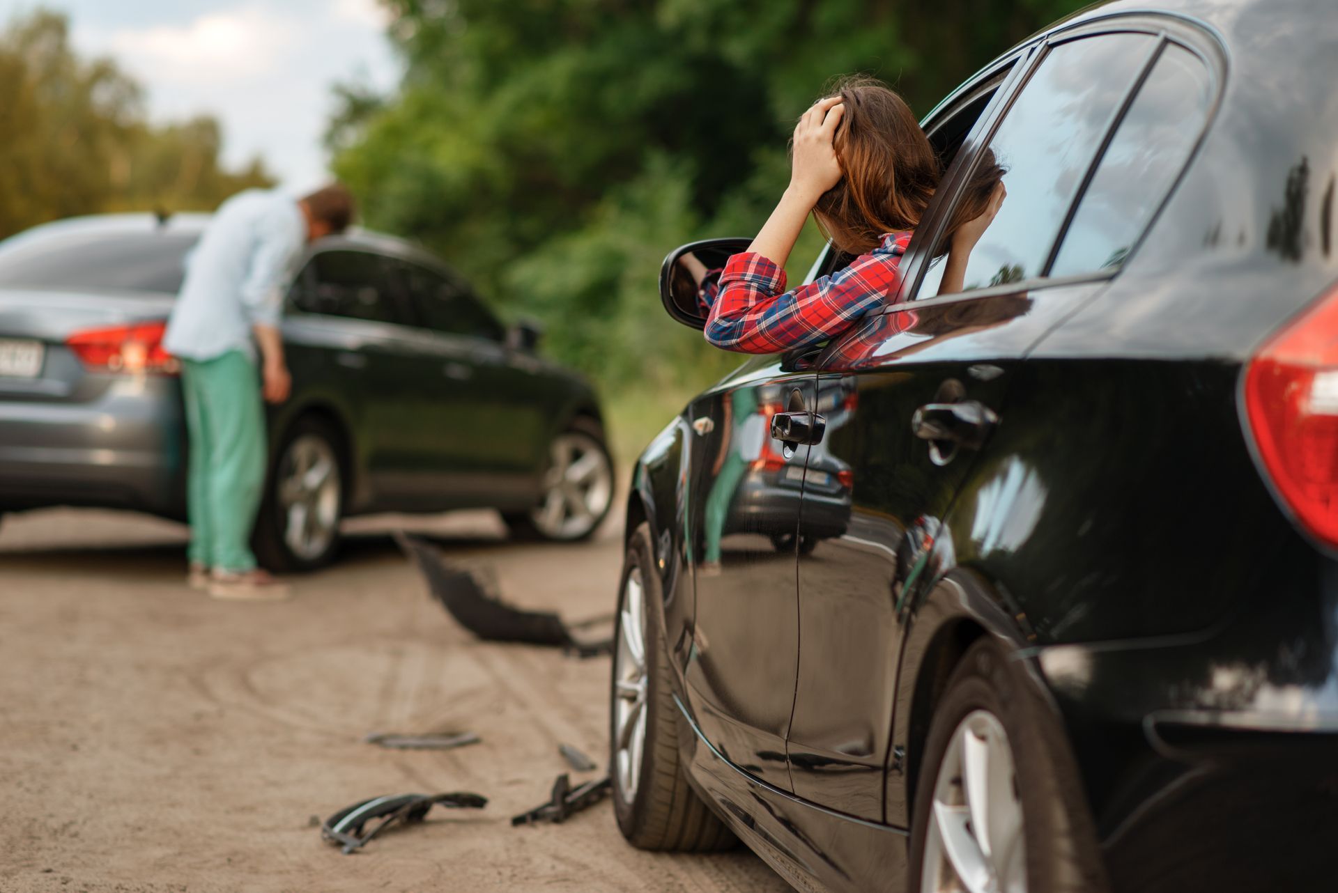 Male and female drivers after car accident on road.