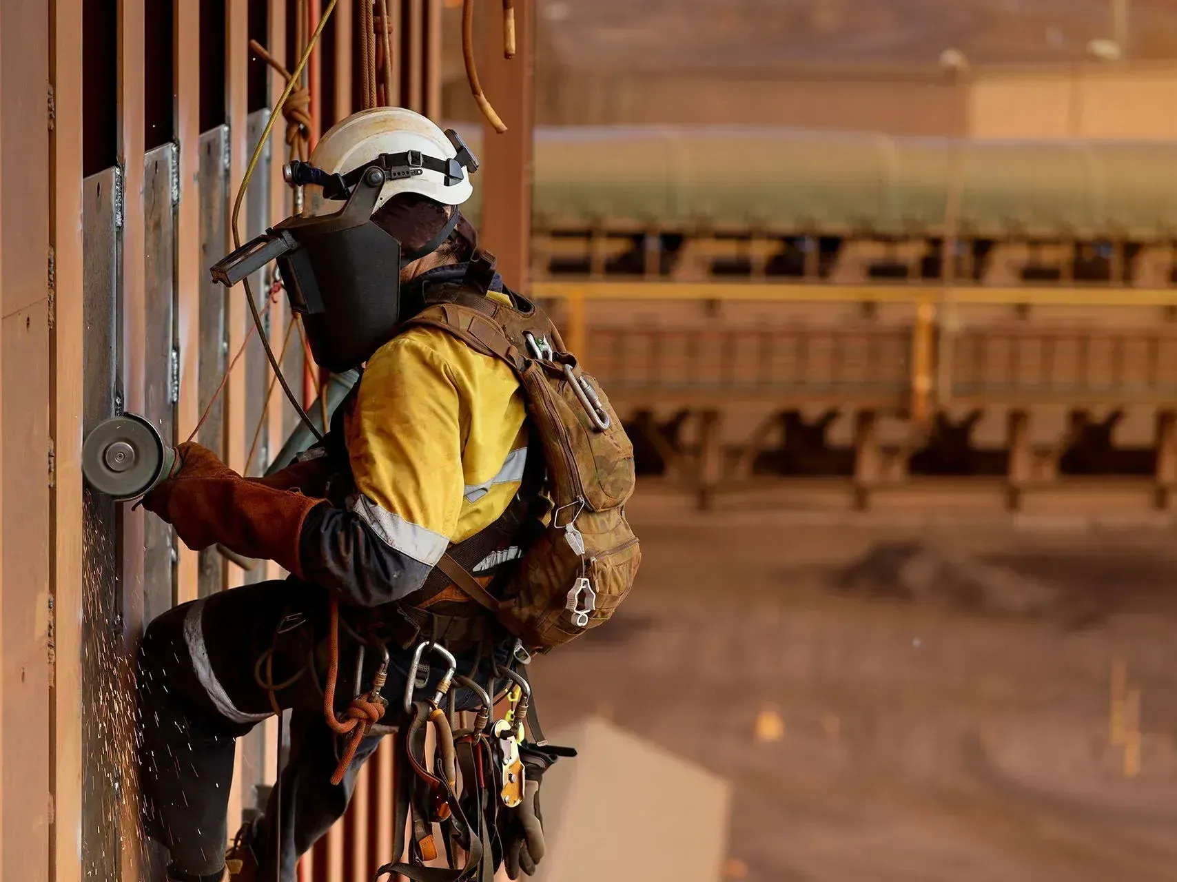 A man wearing a helmet and gloves is working on a wall.