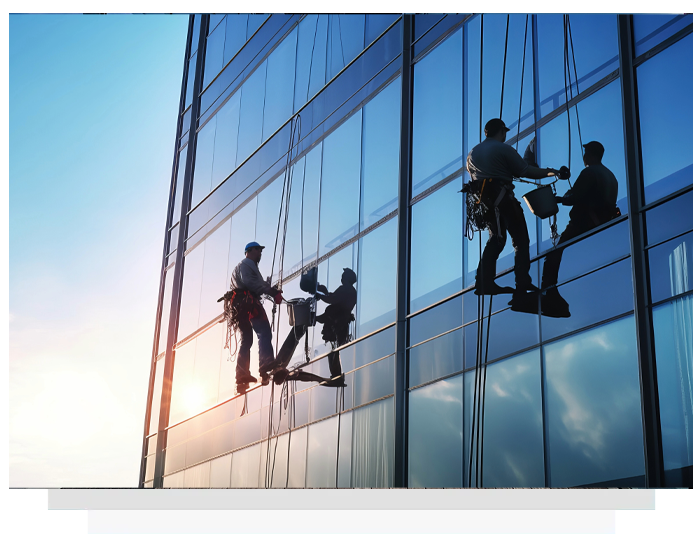 Window washers suspended from ropes cleaning a tall glass building.