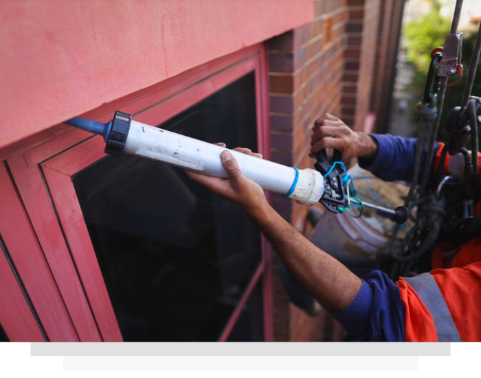 Worker rappels down a skyscraper, inspecting a window. Tablet displays a color-coded analysis chart.