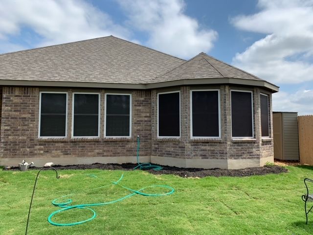 A house with a lot of windows and a hose in front of it.