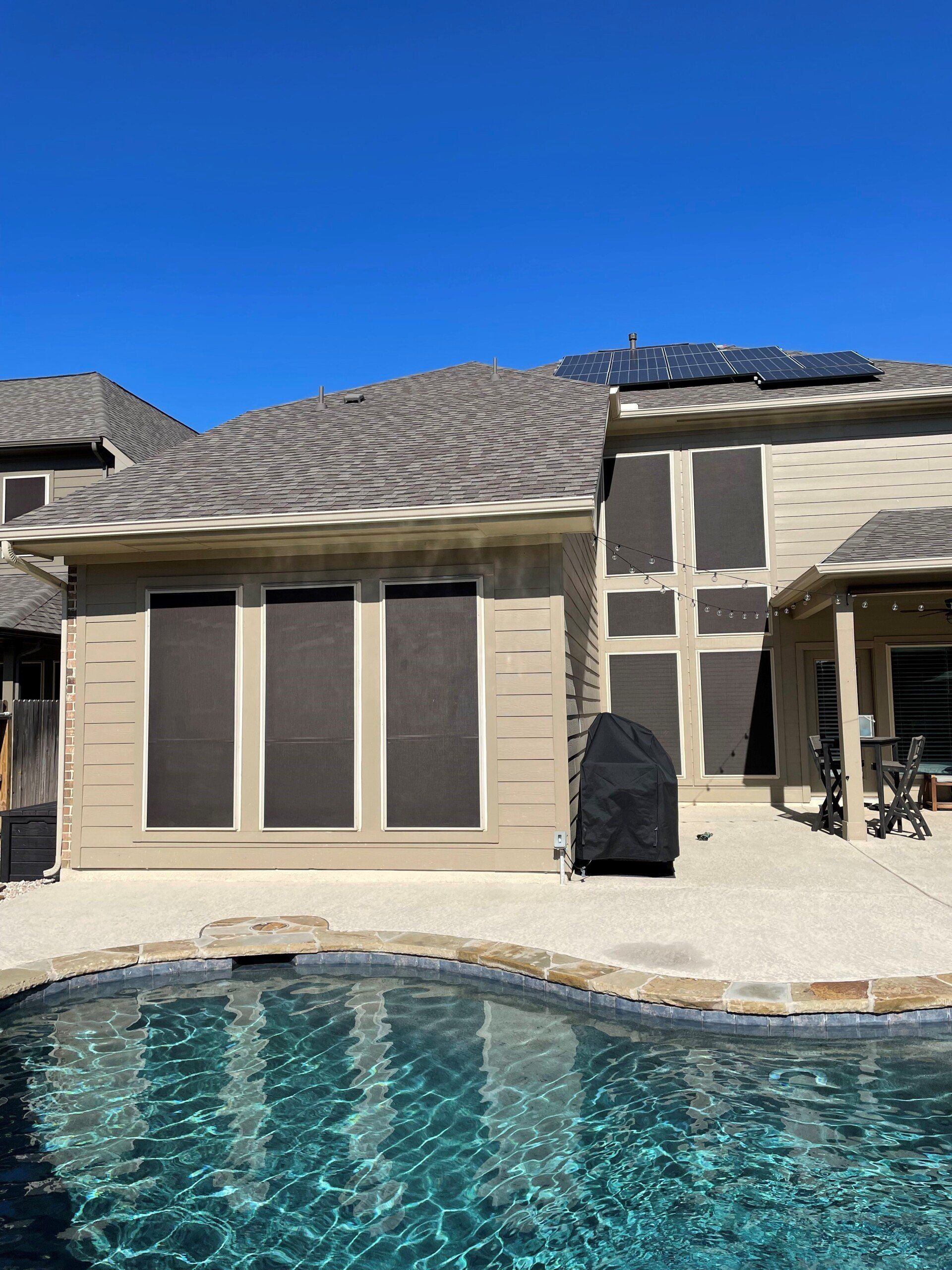 A large house with a swimming pool in front of it.