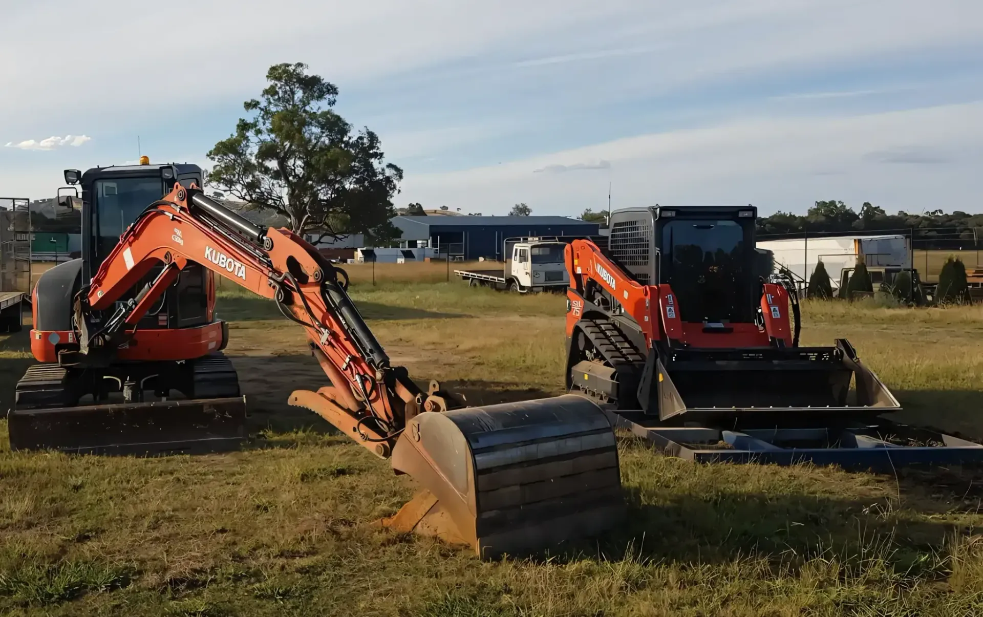 A Dump Truck Is Towing A Large Excavator On A Flatbed Trailer — Grants Excavations In Osbornes Flat, VIC