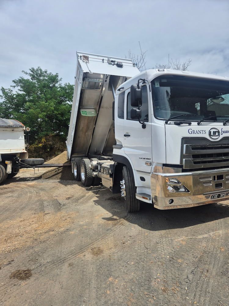 A White Dump Truck Is Parked On Dirt — Grants Excavations In Osbornes Flat, VIC
