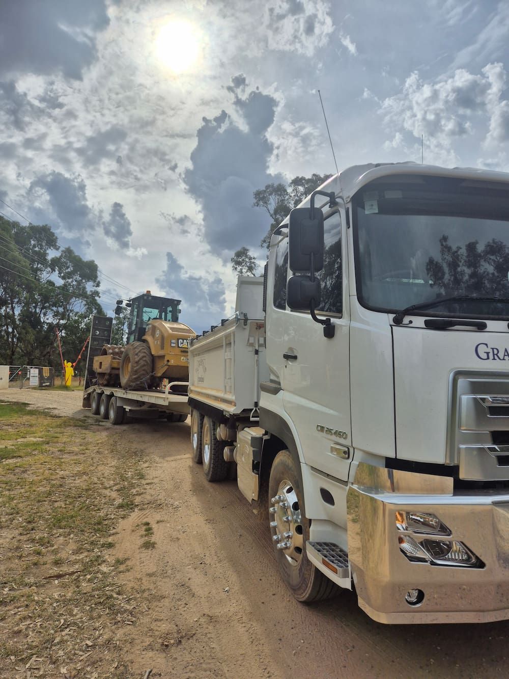 A Dump Truck Is Parked On The Side Of The Road Next To A Bulldozer — Grants Excavations In Osbornes Flat, VIC