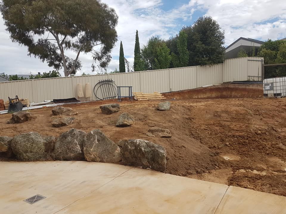 A Large Pile Of Dirt And Rocks In A Yard With A White Fence In The Background — Grants Excavations In Osbornes Flat, VIC