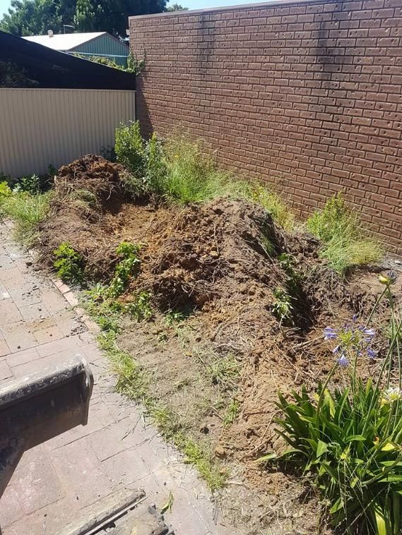A Pile Of Dirt Is Sitting In Front Of A Brick Wall — Grants Excavations In Osbornes Flat, VIC