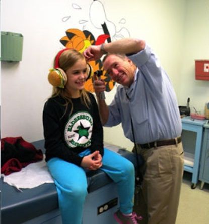A doctor checking a young girl's ear. 