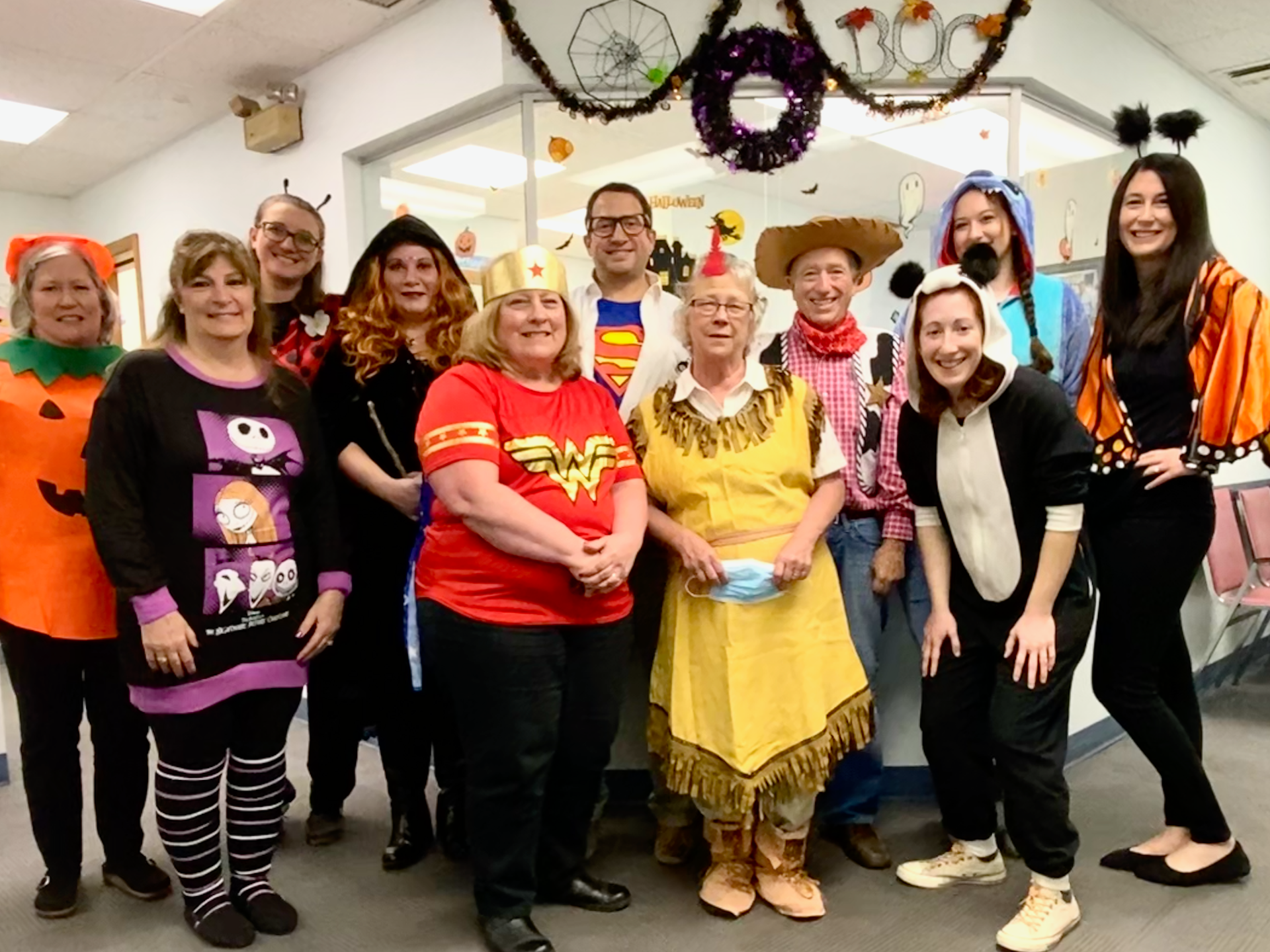 A group of people dressed in halloween costumes are posing for a picture.