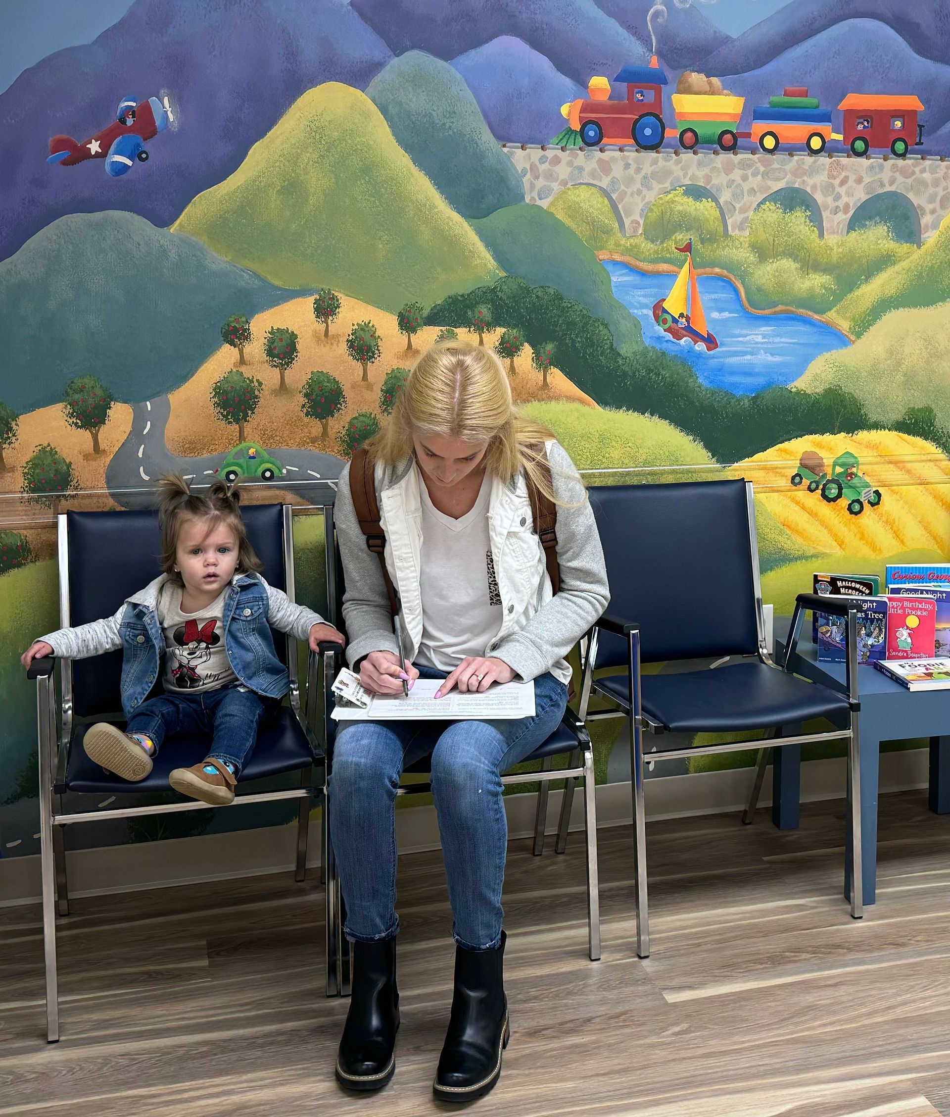 Mom completing patient forms in the waiting room at a pediatricians office