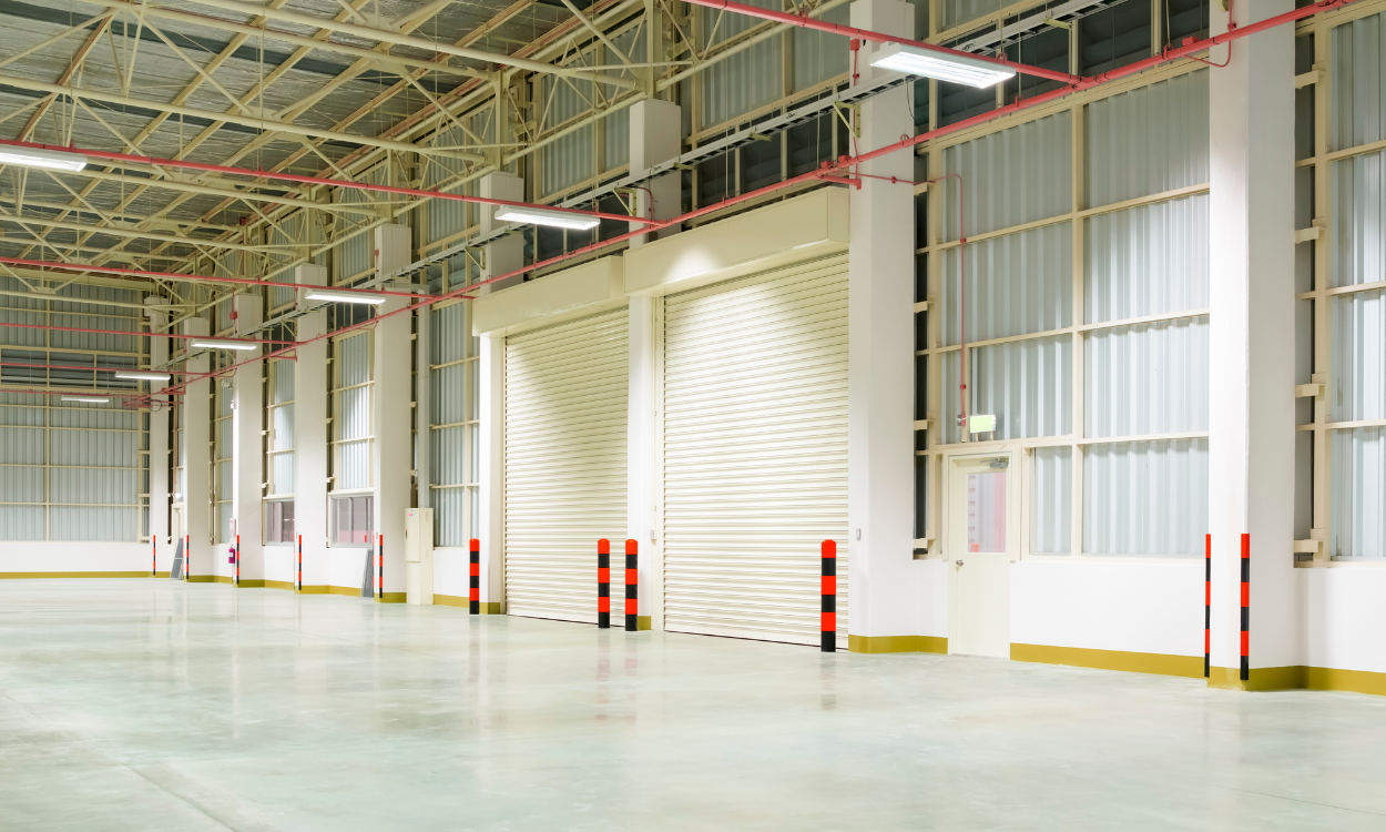 Empty industrial warehouse interior with high ceiling, white walls, and red-and-white safety columns Remote Monitoring & Diagnostics for Modern Heating Solutions