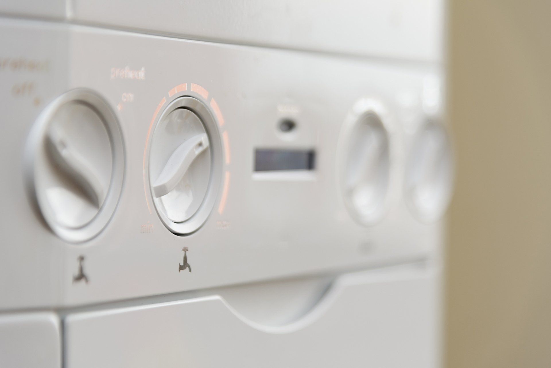 A close up of a white boiler with a bunch of buttons on it.