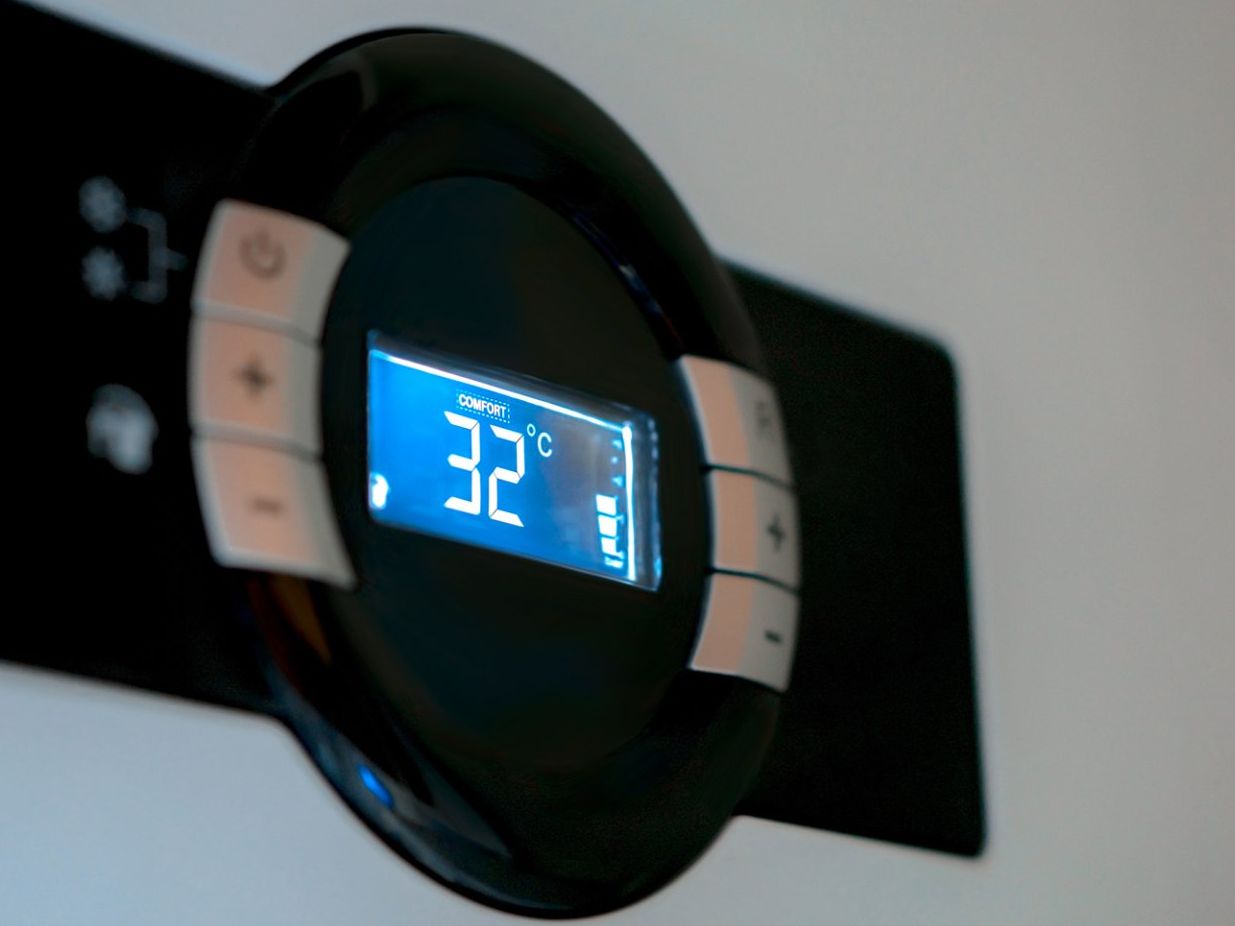 A thermostat displays the temperature as 32 degrees