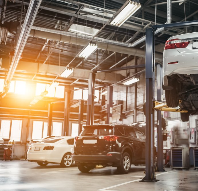 A car is on a lift in a garage. garage looks warm from a warm air heater