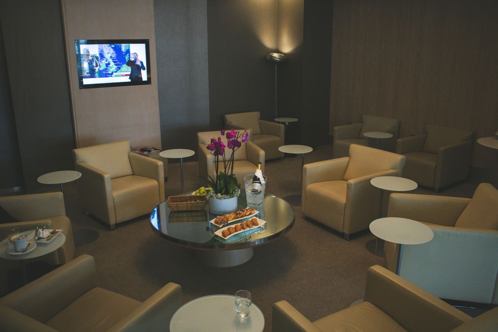 A living room filled with chairs , tables and a flat screen tv.