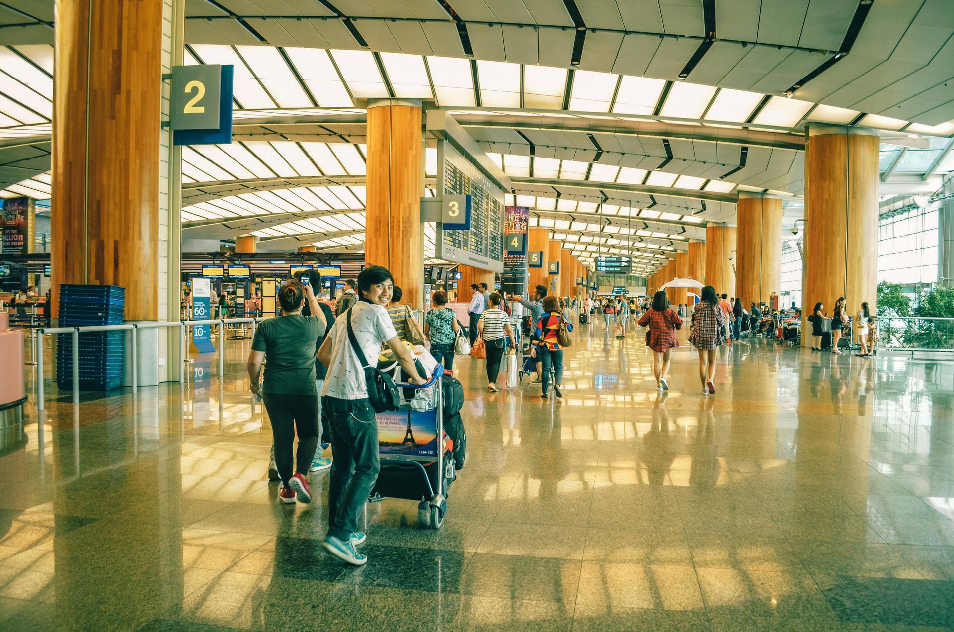 A group of people are walking through an airport terminal.