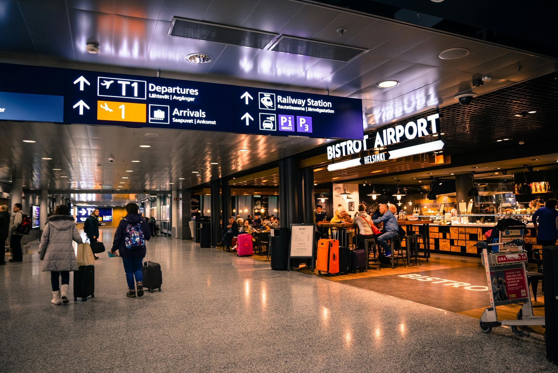 A group of people are walking through an airport with luggage.