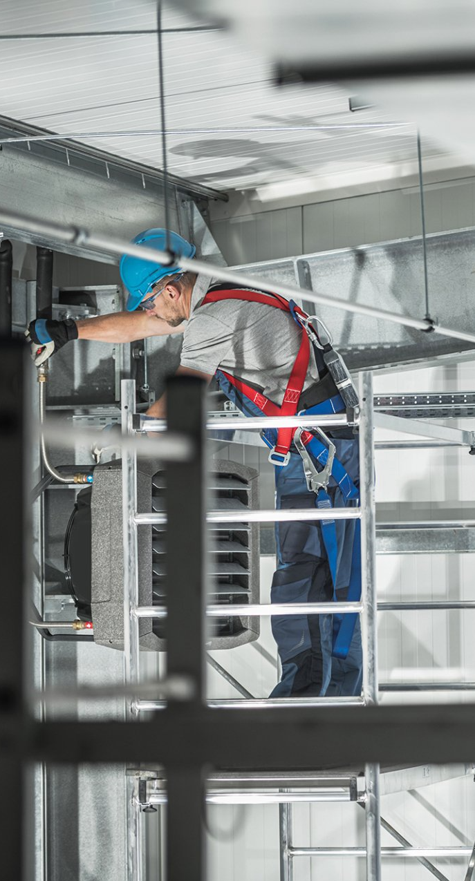 A man is working on a ceiling in a building.